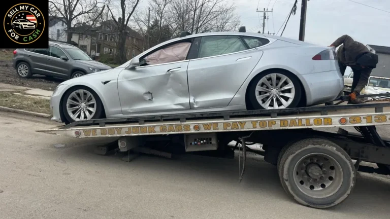 Damaged silver car being loaded onto a tow truck for junk car removal and cash sa